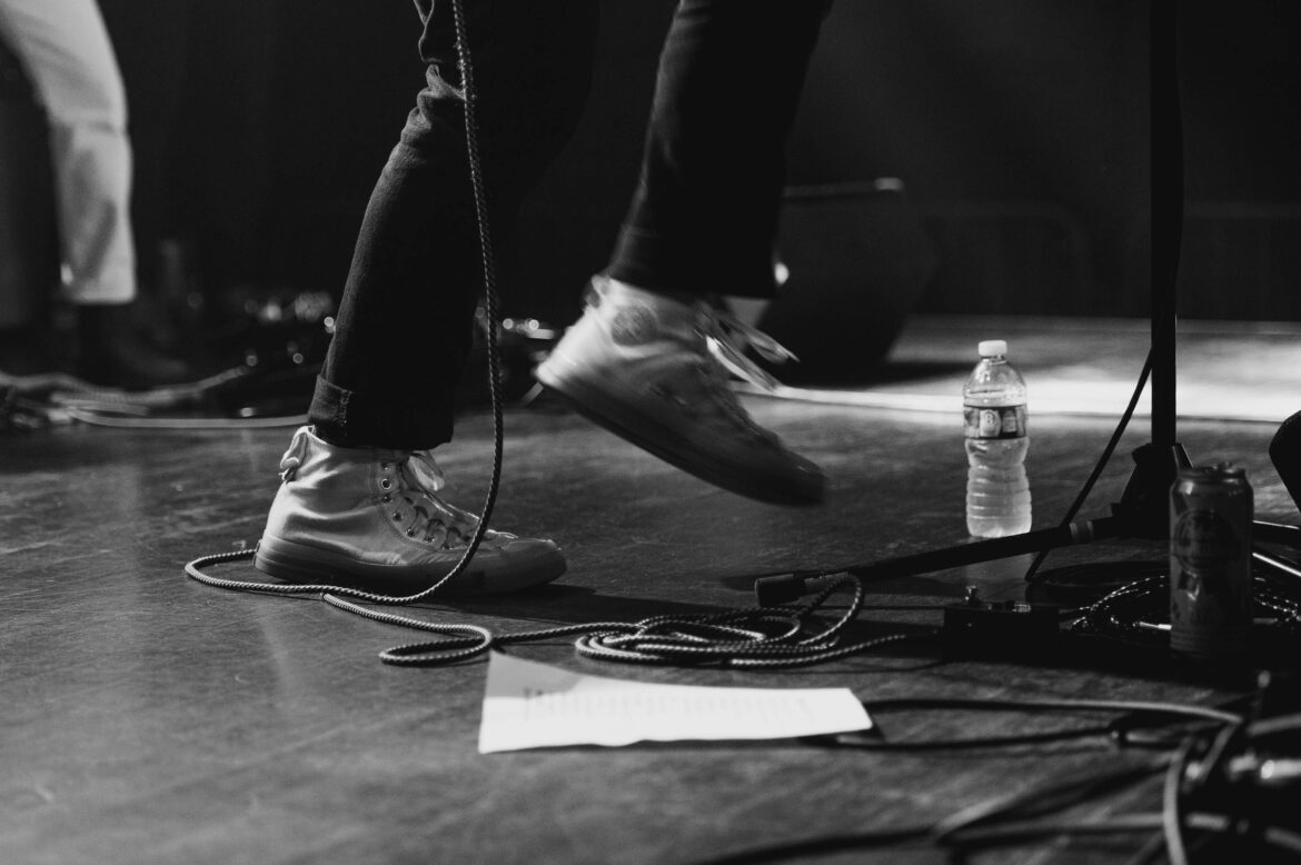 a close up of a man's sneakers onstage at brighton music hall by boston music photographer lisa czech